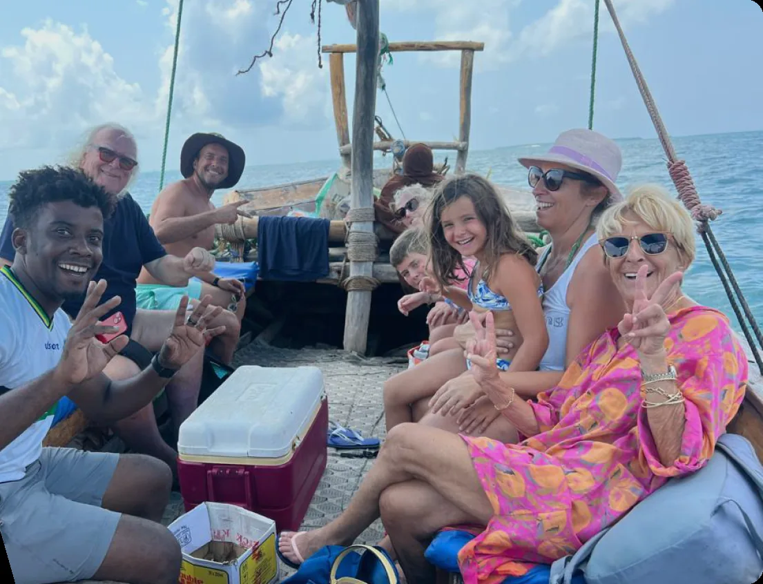 Travel guests and a local guide smiling on a Zanzibar boat activity